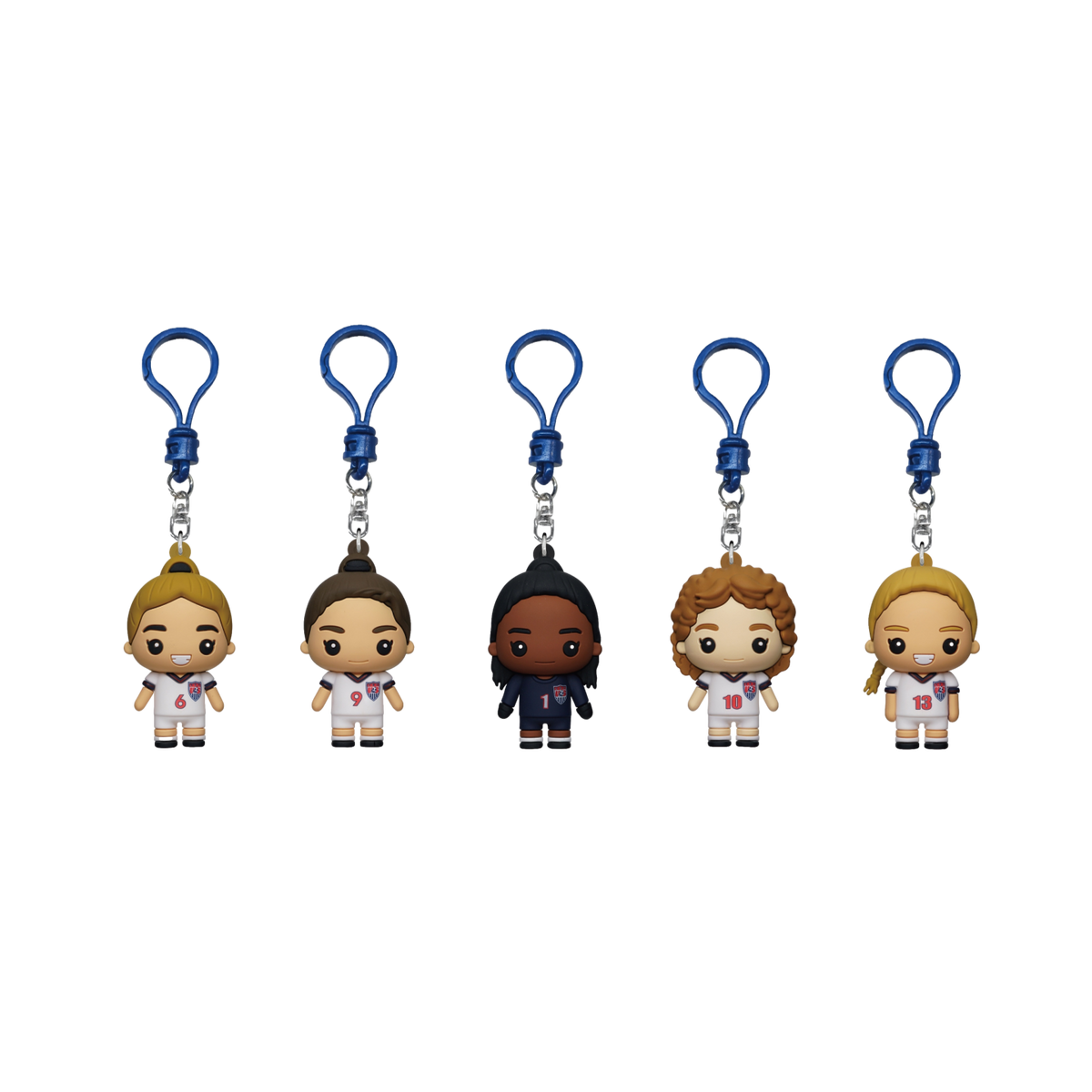 A Monogram 99ers 1999 Womens World Cup Champions 5 Piece Bag Clip Set featuring five stylized, cartoon-like figurines of soccer players in US jerseys. Each figure is hanging from a blue plastic clip and represents a different player with jersey numbers 6,