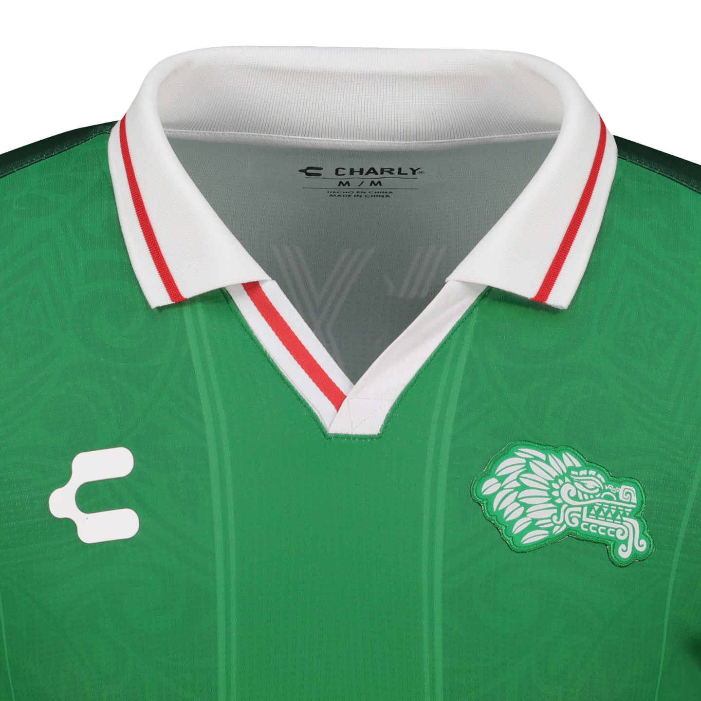 Close-up of a green Charly soccer jersey with a white polo collar trimmed in red. Features a white brand logo and a green stylized lion crest.