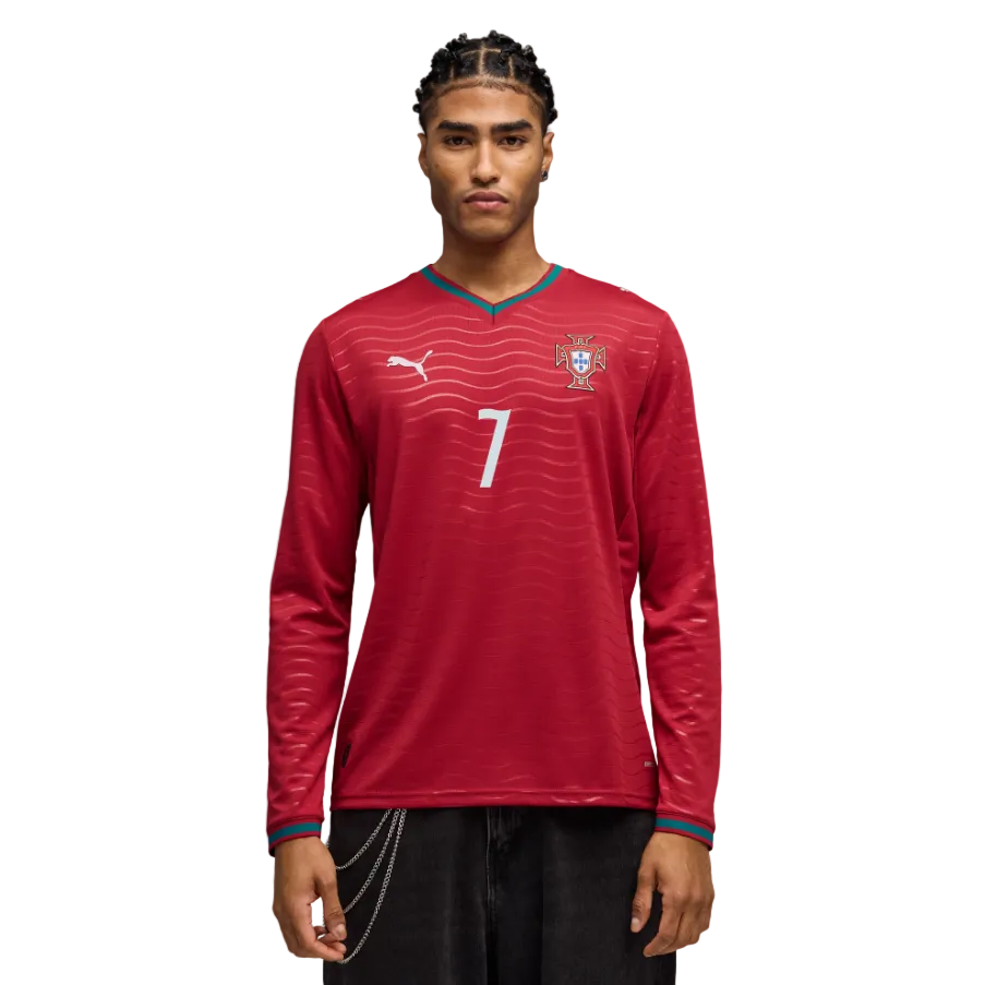 A man models a red long-sleeved Portugal soccer jersey with a white number 7, a Puma logo, and teal trim against a black background.
