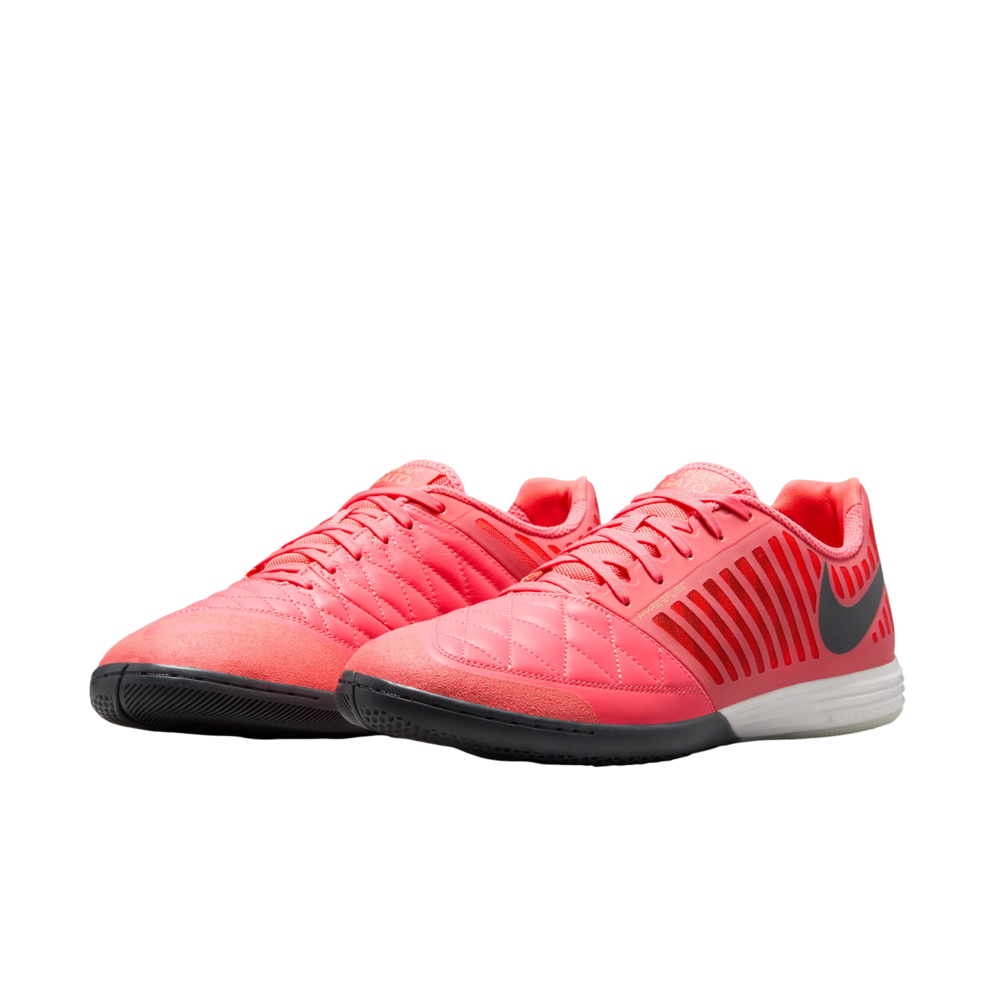 A pair of bright coral Nike Lunar Gato II indoor soccer shoes with black swooshes and white midsoles on a white background.