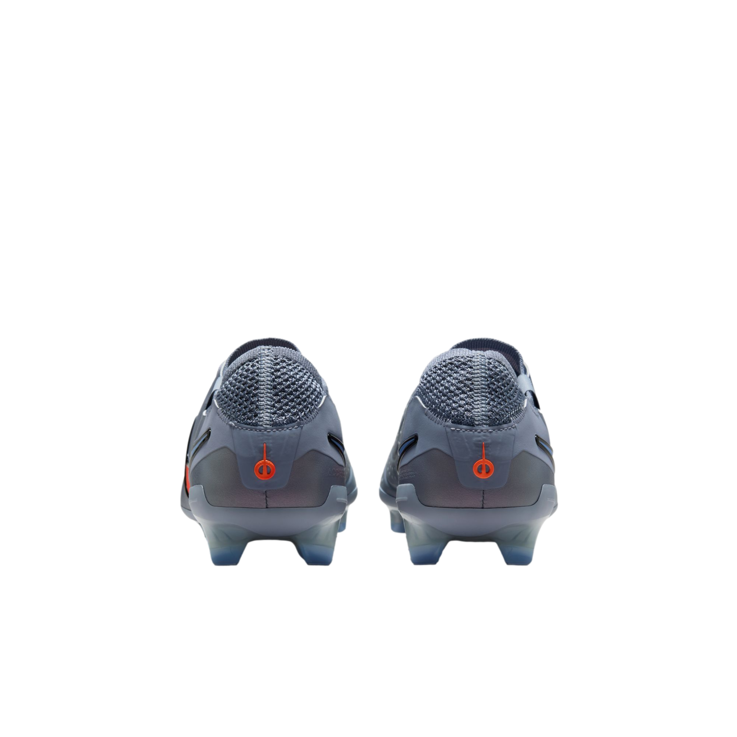 Rear view of a pair of light grey soccer cleats featuring orange circular logos on the heels, against a black background.