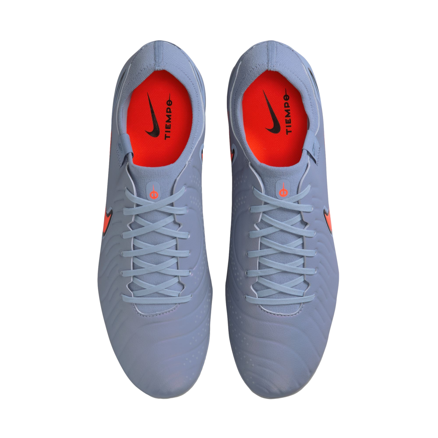 Top-down view of a pair of light blue Nike Tiempo soccer cleats with bright orange insoles and black branding, set against a solid black background.