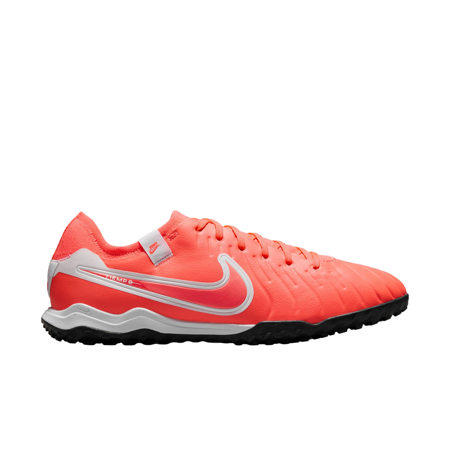 Side view of a bright orange Nike Tiempo turf soccer shoe. It features a large white swoosh, a white midsole, and a black studded rubber outsole.