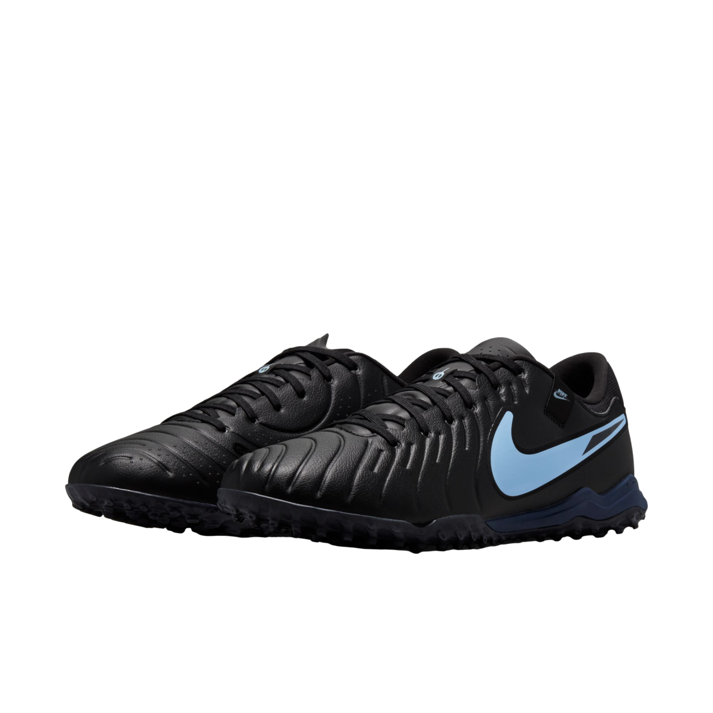 A pair of black Nike turf soccer shoes with light blue accents and textured uppers, shown against a black background.
