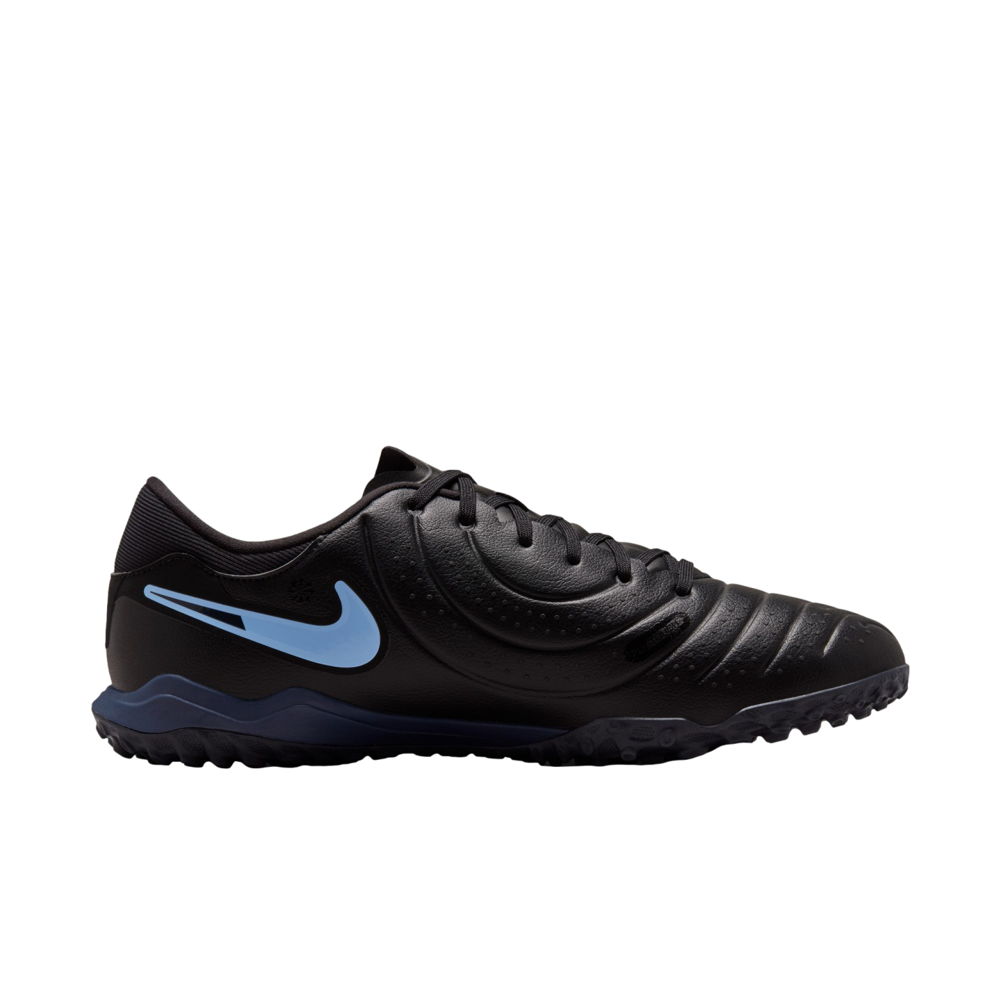 A side profile of a black Nike turf soccer shoe with a light blue swoosh and dark blue sole against a black background.