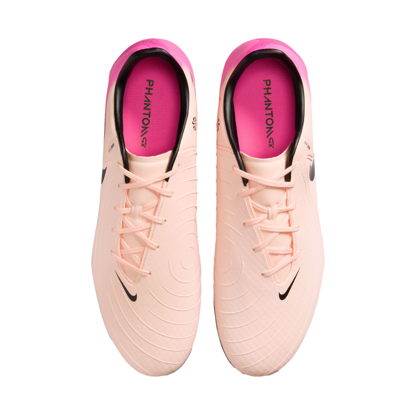Top-down view of a pair of light peach and pink Nike Phantom GX soccer cleats with black Nike logos and bright pink insoles.