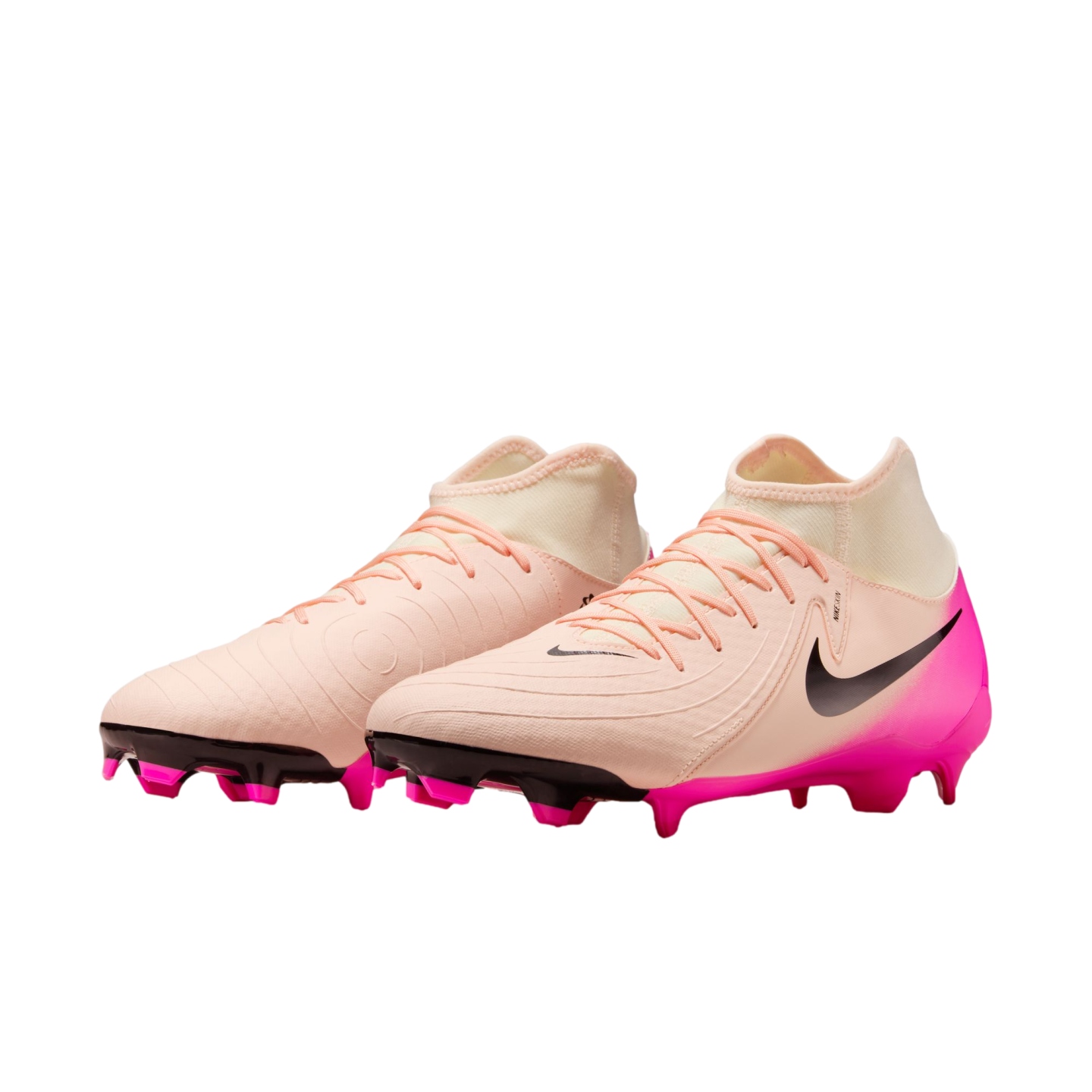 Pair of light peach Nike soccer cleats with bright pink heels and studs. Features a black swoosh and mid-cut collar.