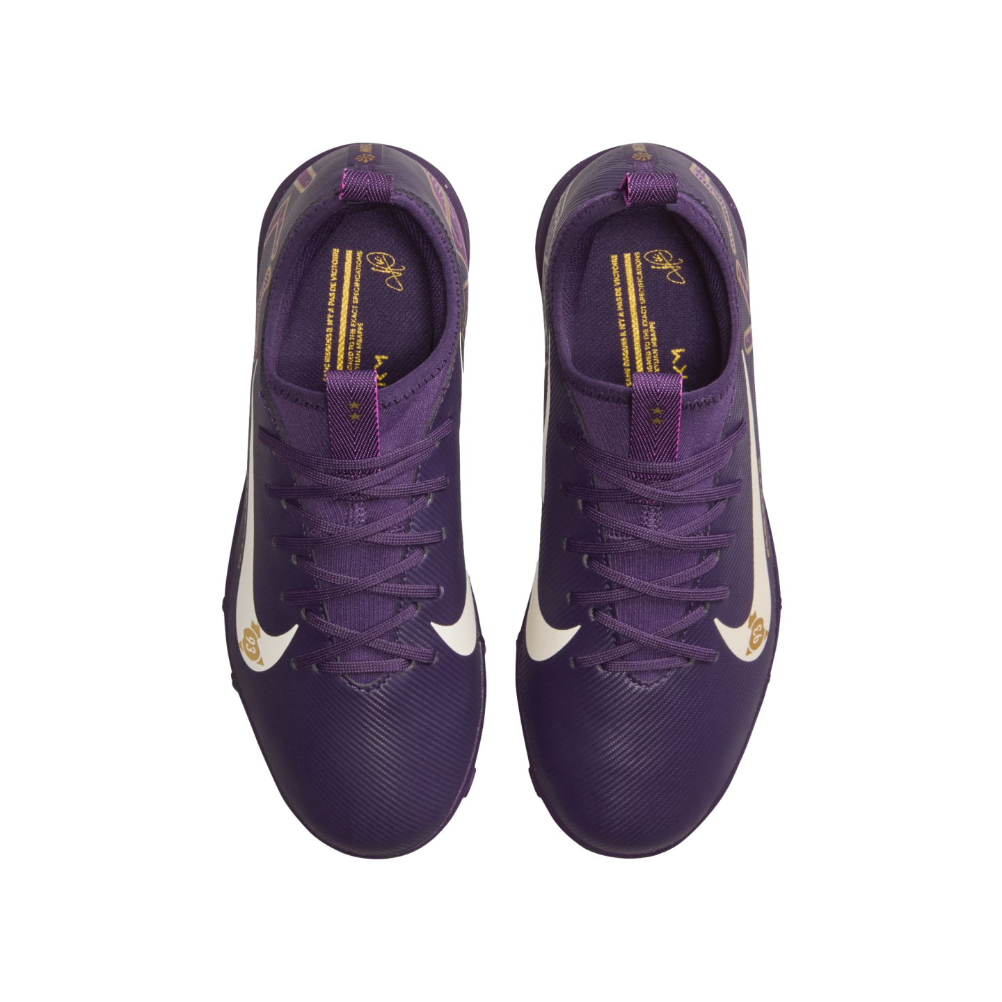 A top-down view of a pair of purple Nike soccer cleats with white swooshes and gold detailing on the tongue and insoles, set against a solid white background.