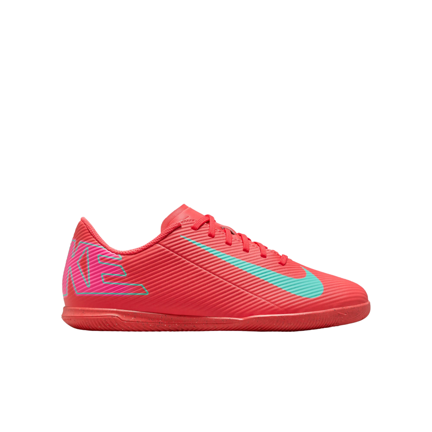 Side view of a bright pink Nike indoor soccer shoe with a teal swoosh and textured upper on a white background.