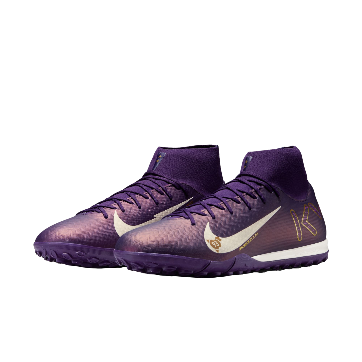 A pair of iridescent purple Nike Mercurial Superfly turf soccer shoes with a white swoosh and gold KM branding, featuring a mid-cut collar.