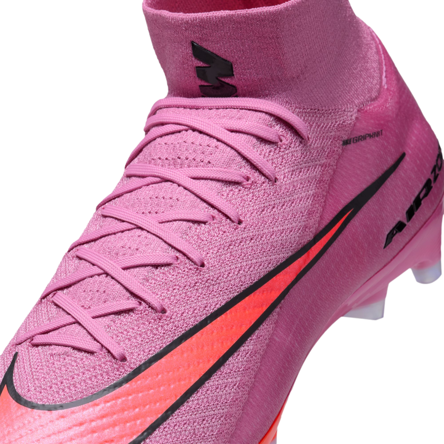 Close-up of a pink Nike soccer cleat featuring an orange swoosh and a high-top Flyknit collar.