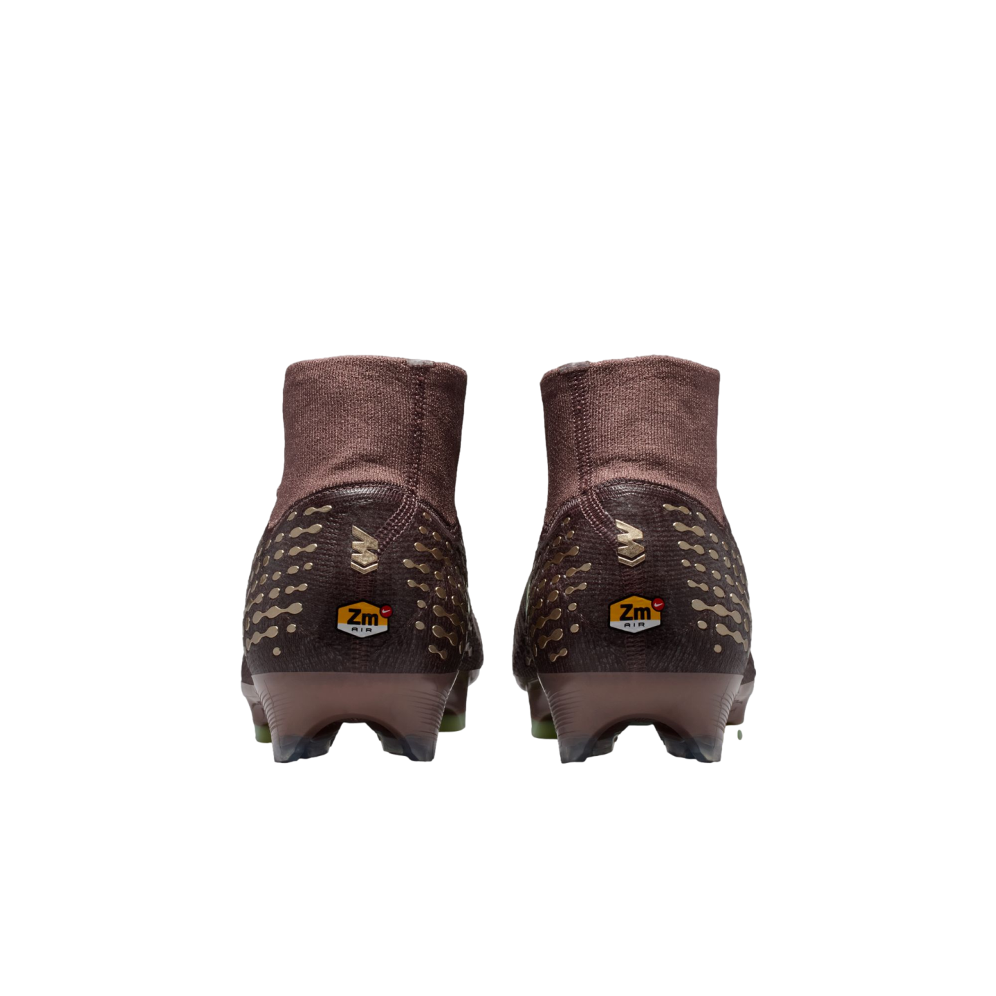 Rear view of two brown and gold Nike soccer cleats with high-top collars and "Zm AIR" logos on the heels, set against a black background.