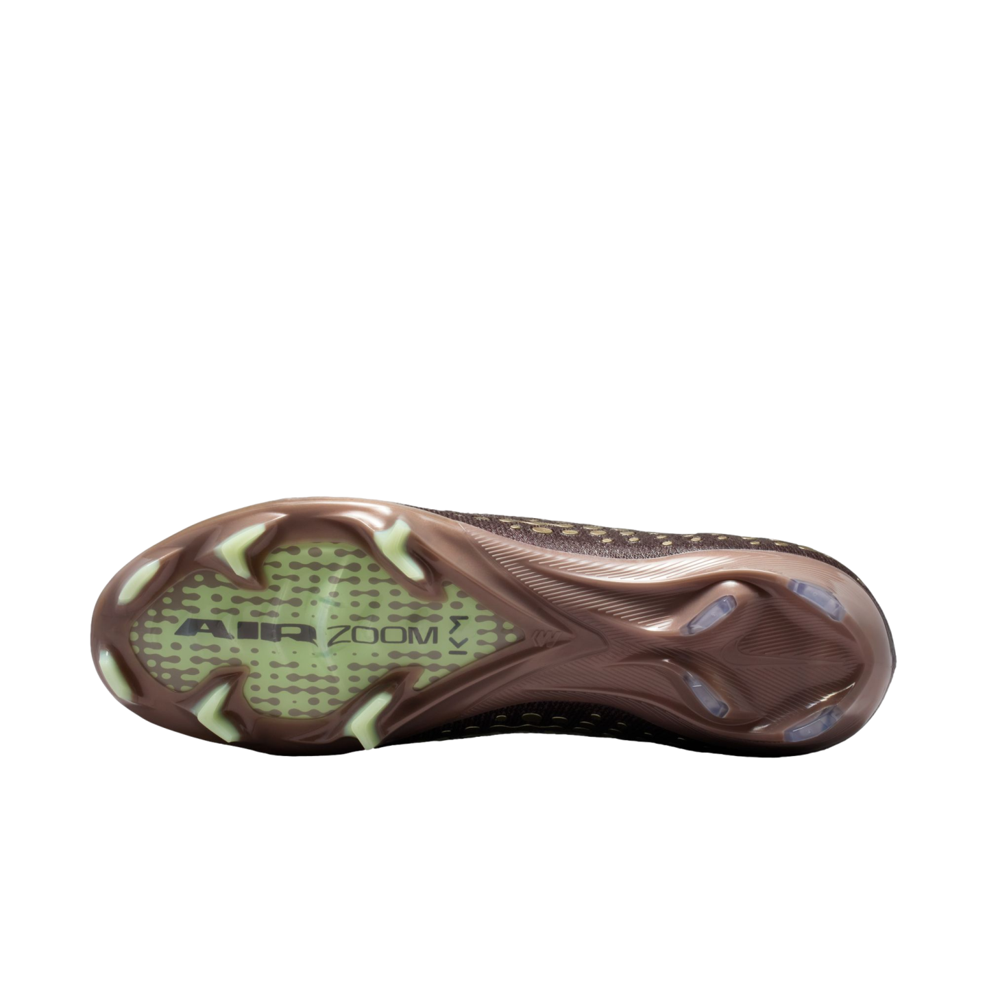Bottom sole of a bronze Nike soccer cleat with "AIR ZOOM" and "KM" branding, featuring light-colored studs on a solid black background.
