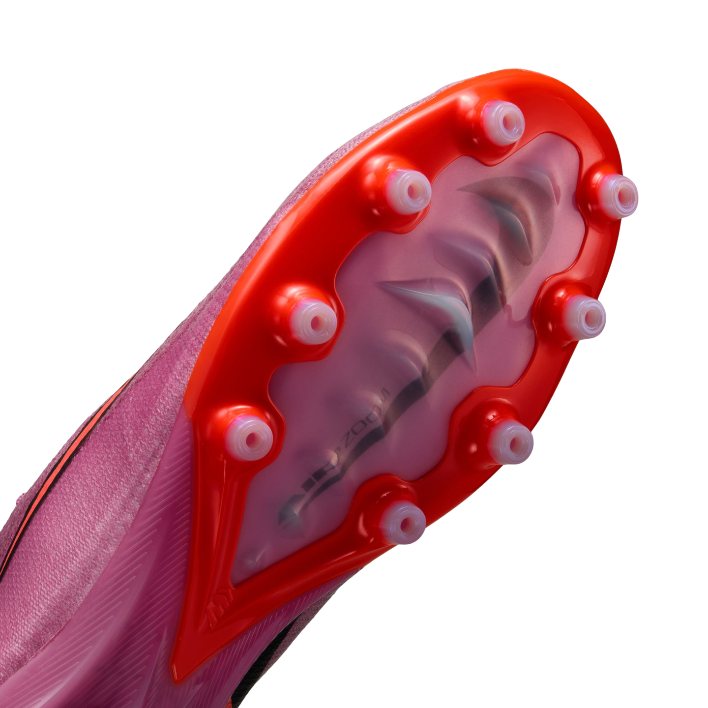 Close-up of a pink Nike soccer cleat's soleplate with bright orange accents and translucent conical studs, showing a visible Air Zoom unit inside.