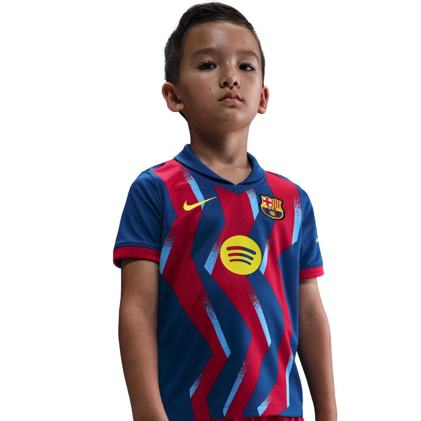 A young boy wearing a blue and red FC Barcelona soccer jersey with a yellow Spotify logo, standing against a black background.