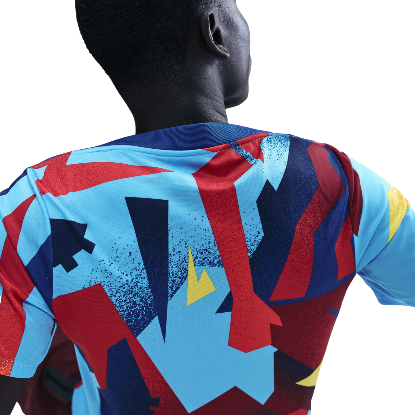 Back view of a person wearing a colorful sports jersey with bold geometric patterns in blue, red, and yellow against a black background.