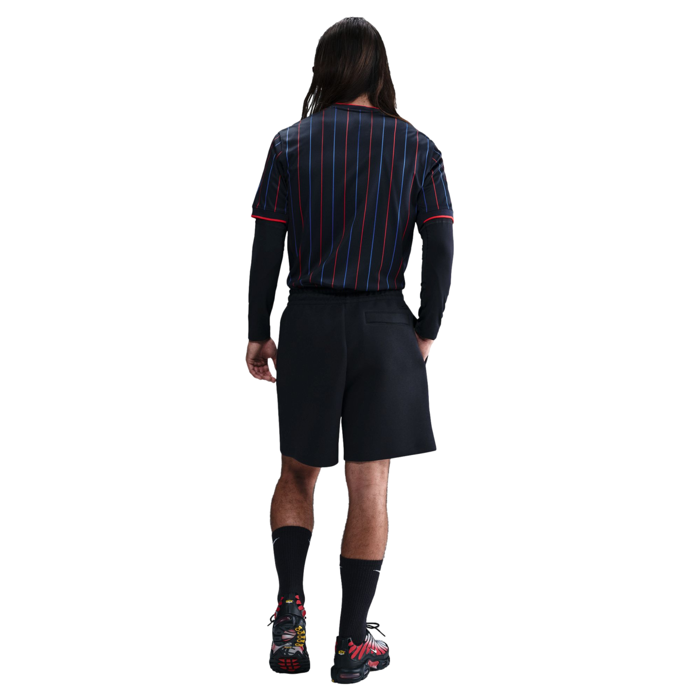 A back view of a person wearing a navy and red pinstriped jersey, black shorts, and black and red sneakers against a white background.