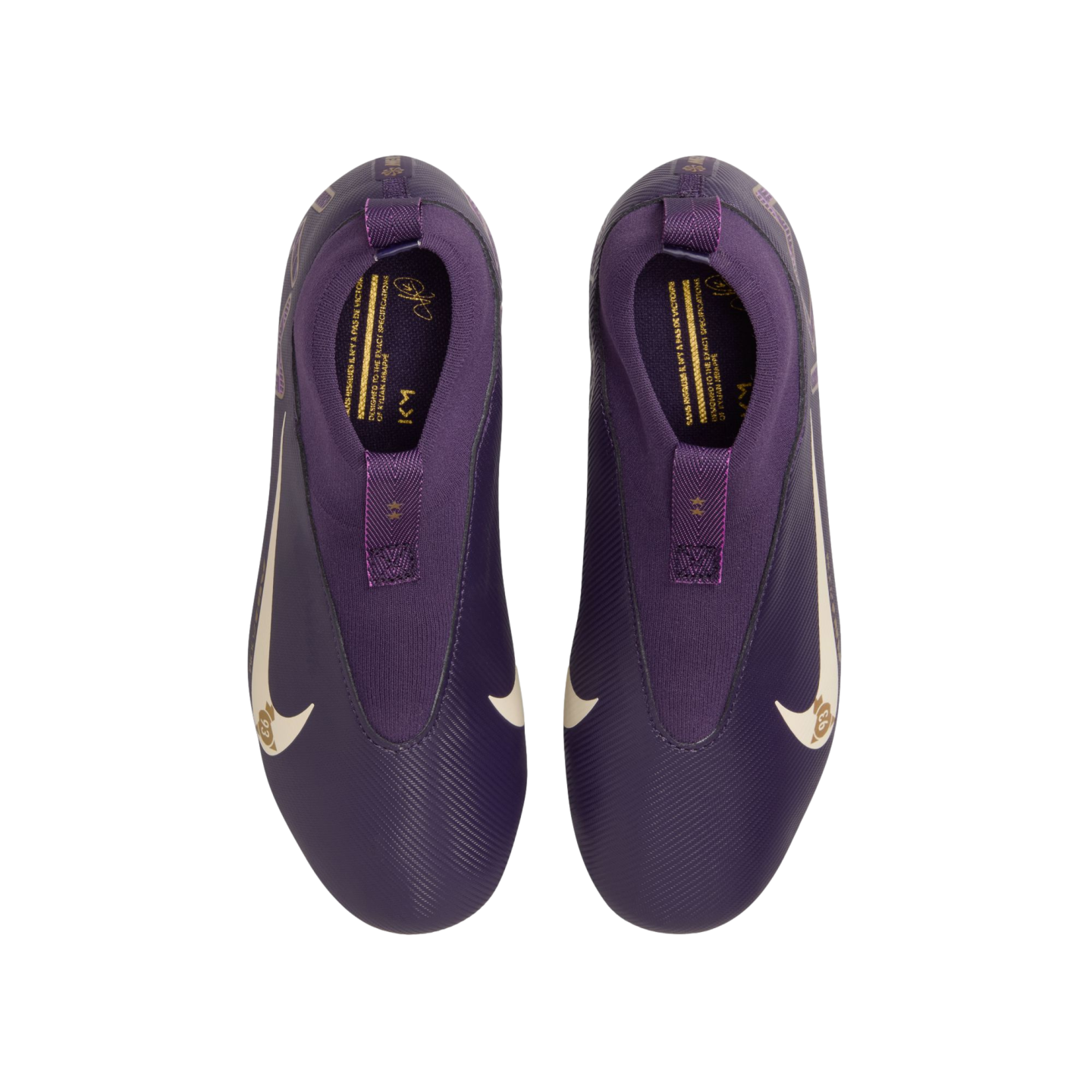 Top-down view of a pair of purple Nike Kylian Mbappé soccer cleats. The laceless boots feature white swooshes and gold branding details inside the collars.