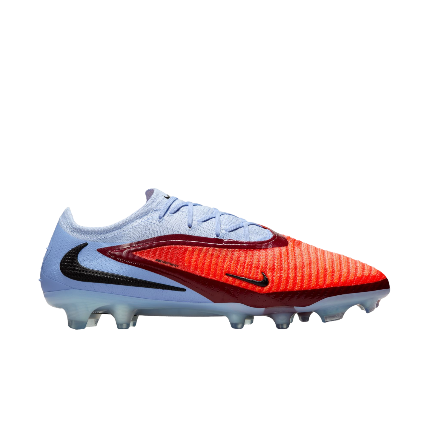 Profile view of a light blue and bright red Nike soccer cleat with maroon accents, black swooshes, and a translucent studded sole.