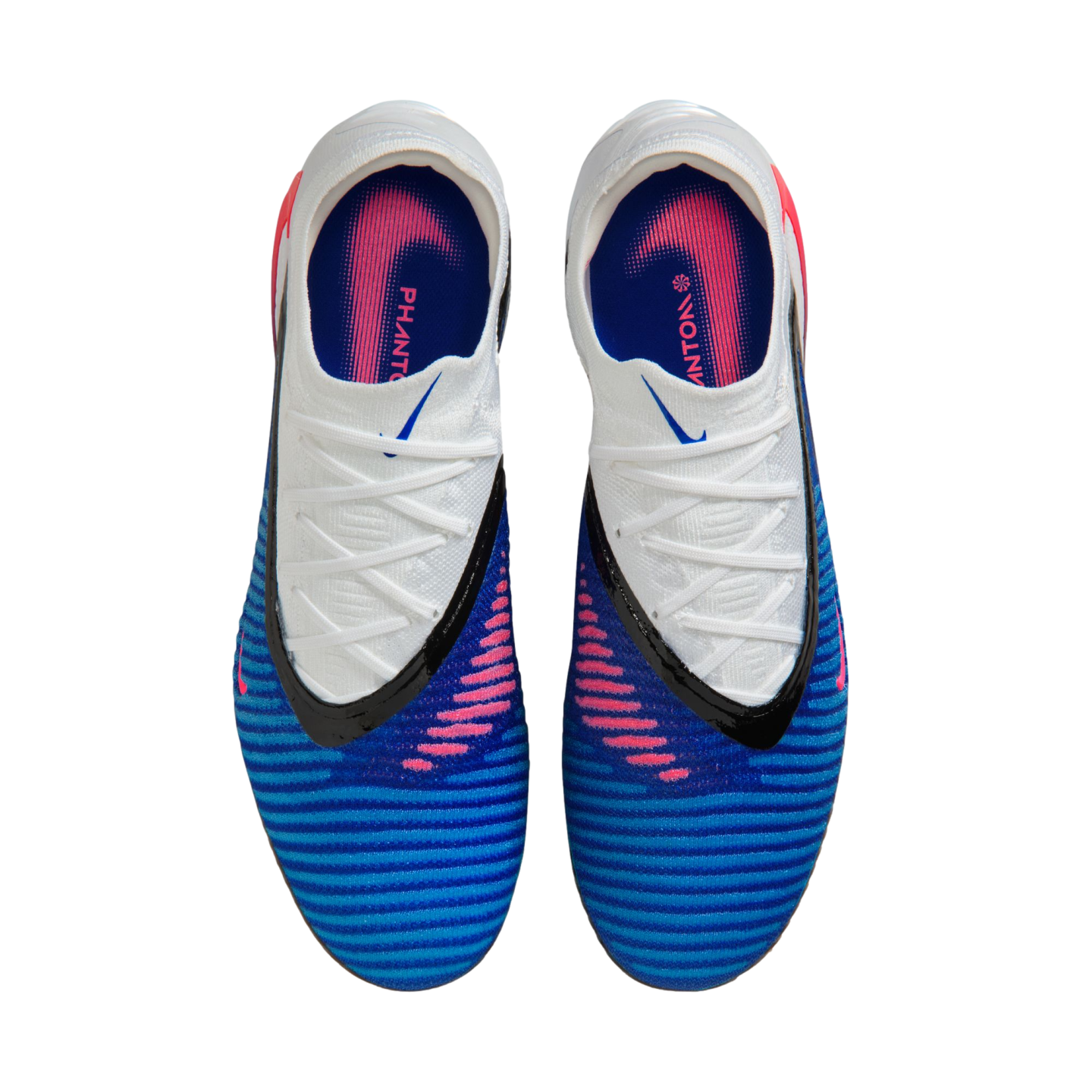 A top-down view of a pair of blue and white Nike Phantom soccer cleats with pink accents and black trim, set against a solid black background.