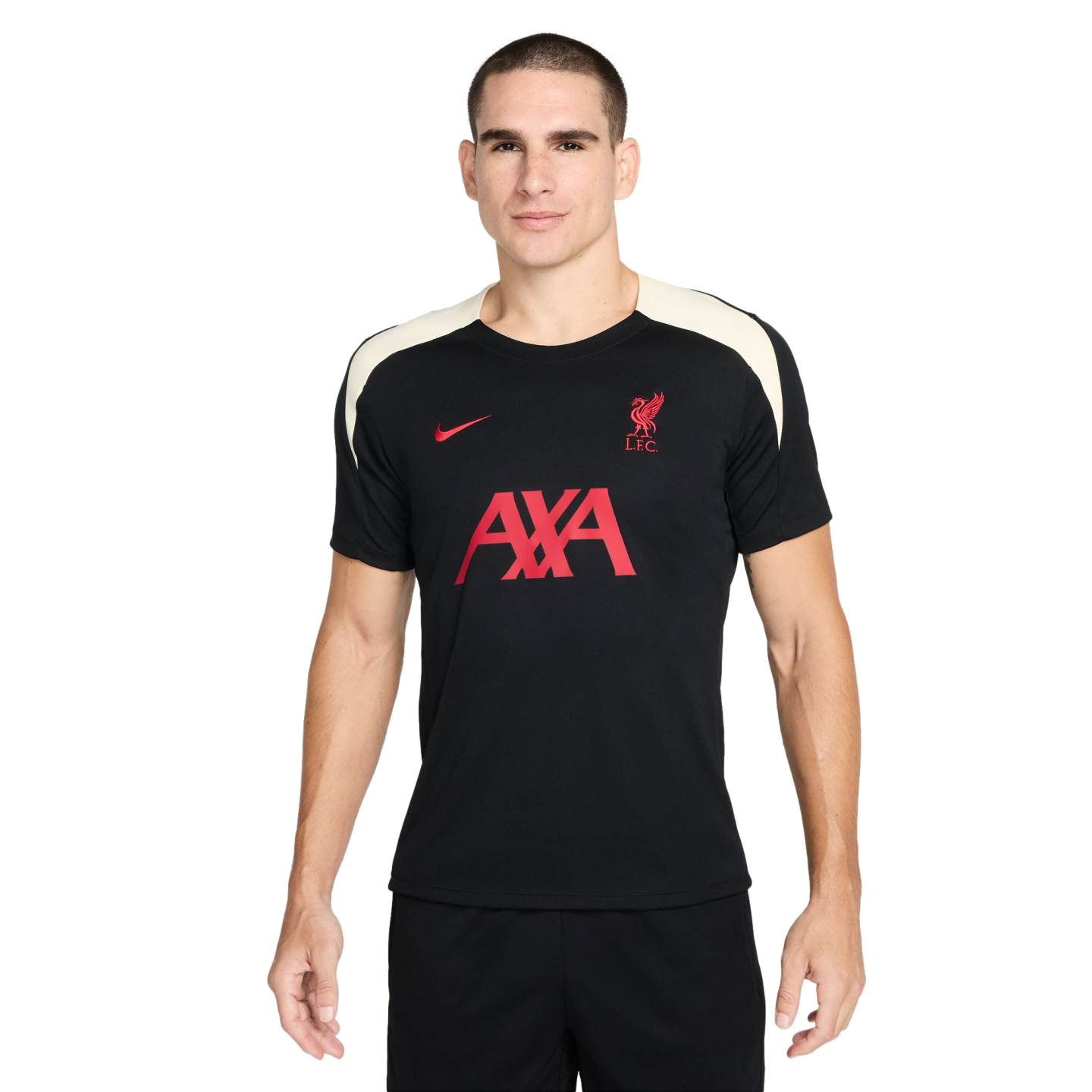 A man stands against a white background wearing a black Liverpool F.C. Nike training shirt with red logos and white shoulder panels.