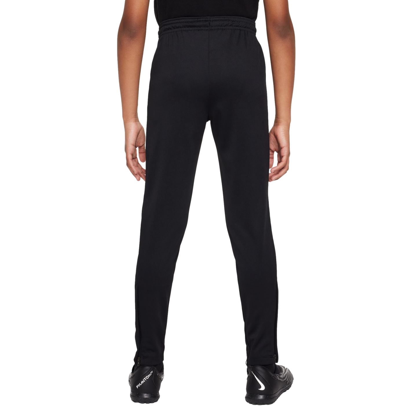 Back view of a person wearing black athletic pants and Nike soccer cleats against a white background.