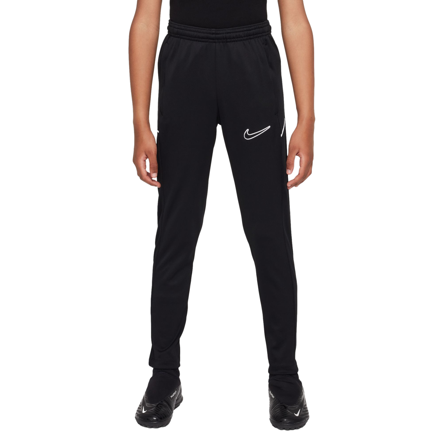 A person wearing black Nike athletic pants with a white swoosh outline on the left thigh and black soccer cleats against a white background.