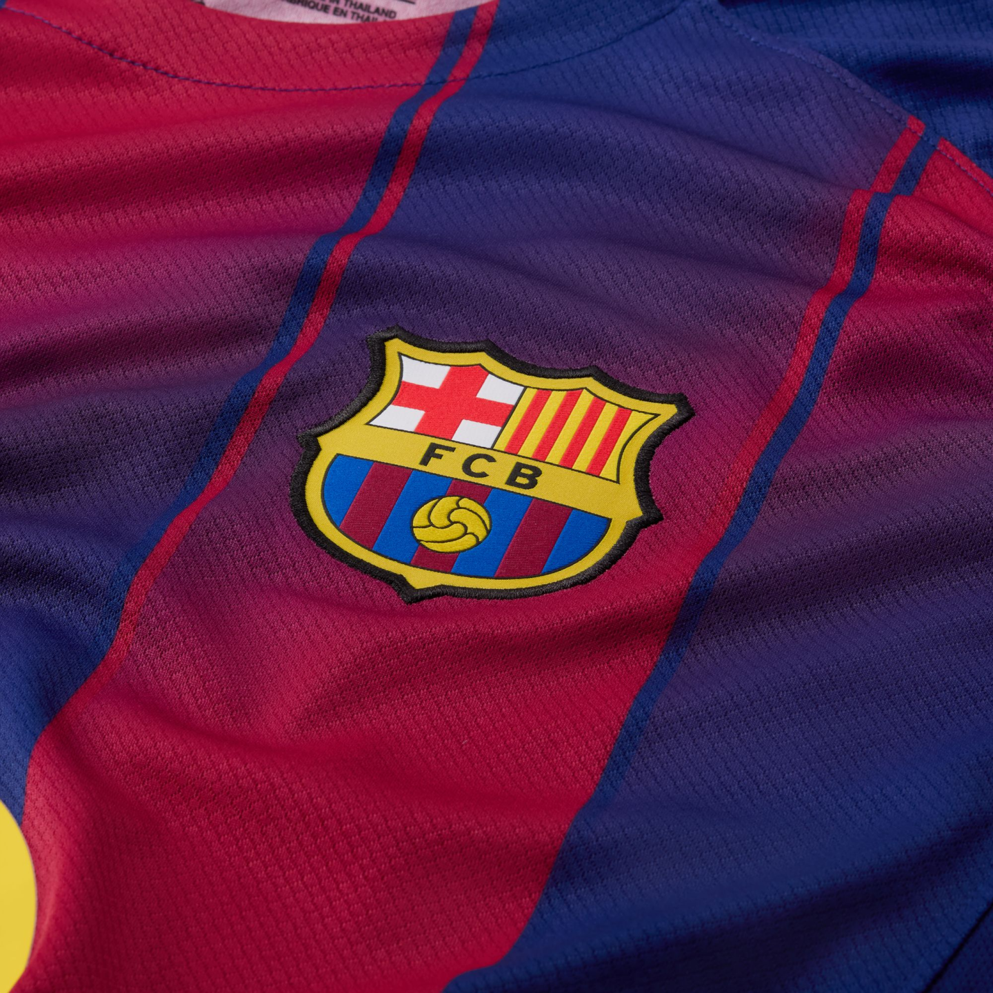 Close-up of a red and blue striped FC Barcelona football jersey featuring the club's crest.