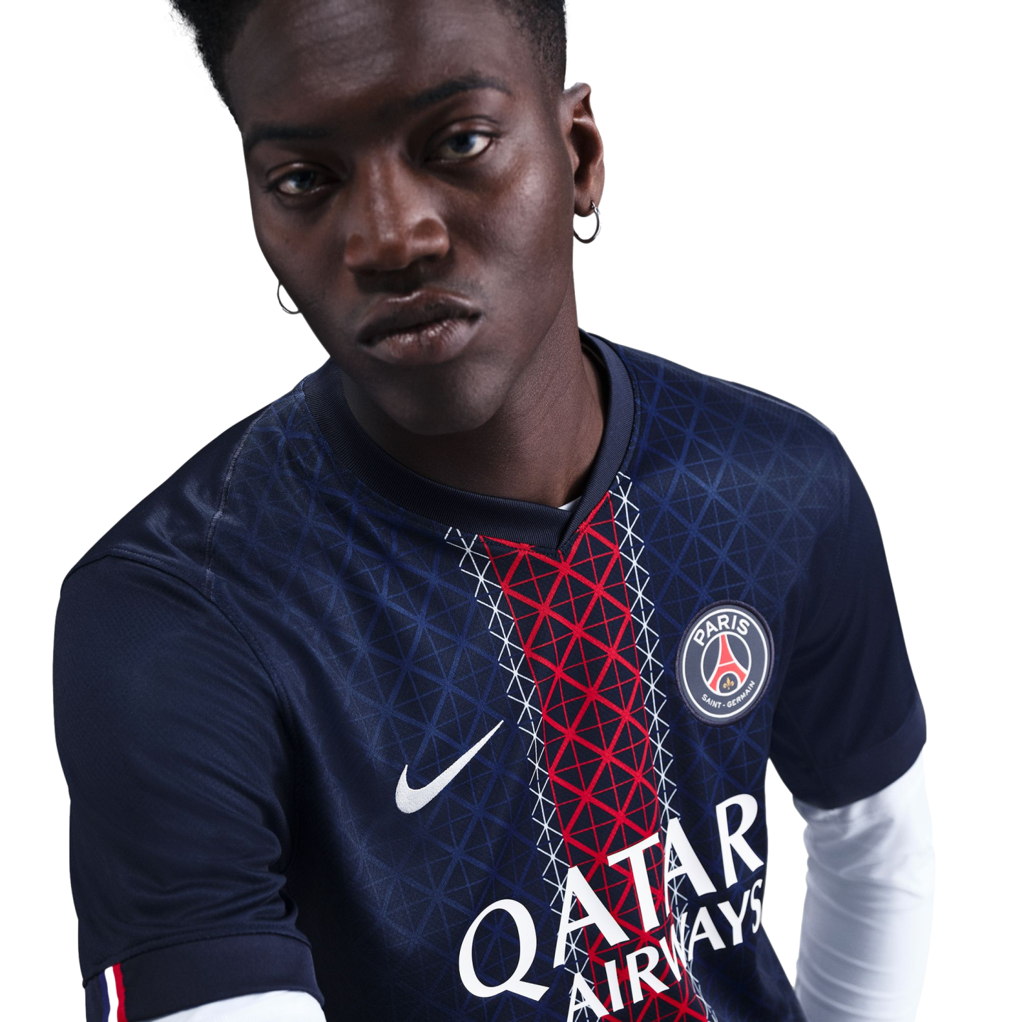 A man wearing a blue Paris Saint-Germain soccer jersey with a red geometric stripe, looking at the camera against a white background.