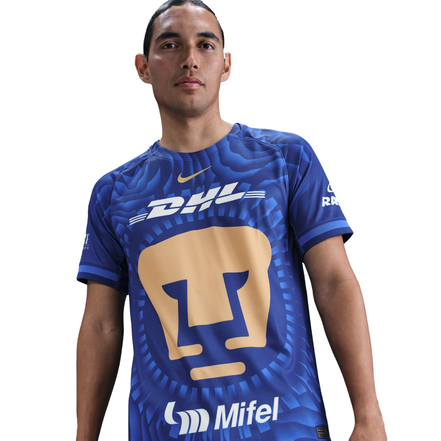 A man wearing a blue Nike Pumas UNAM soccer jersey with a large gold cougar logo and white DHL sponsor branding, isolated on a white background.