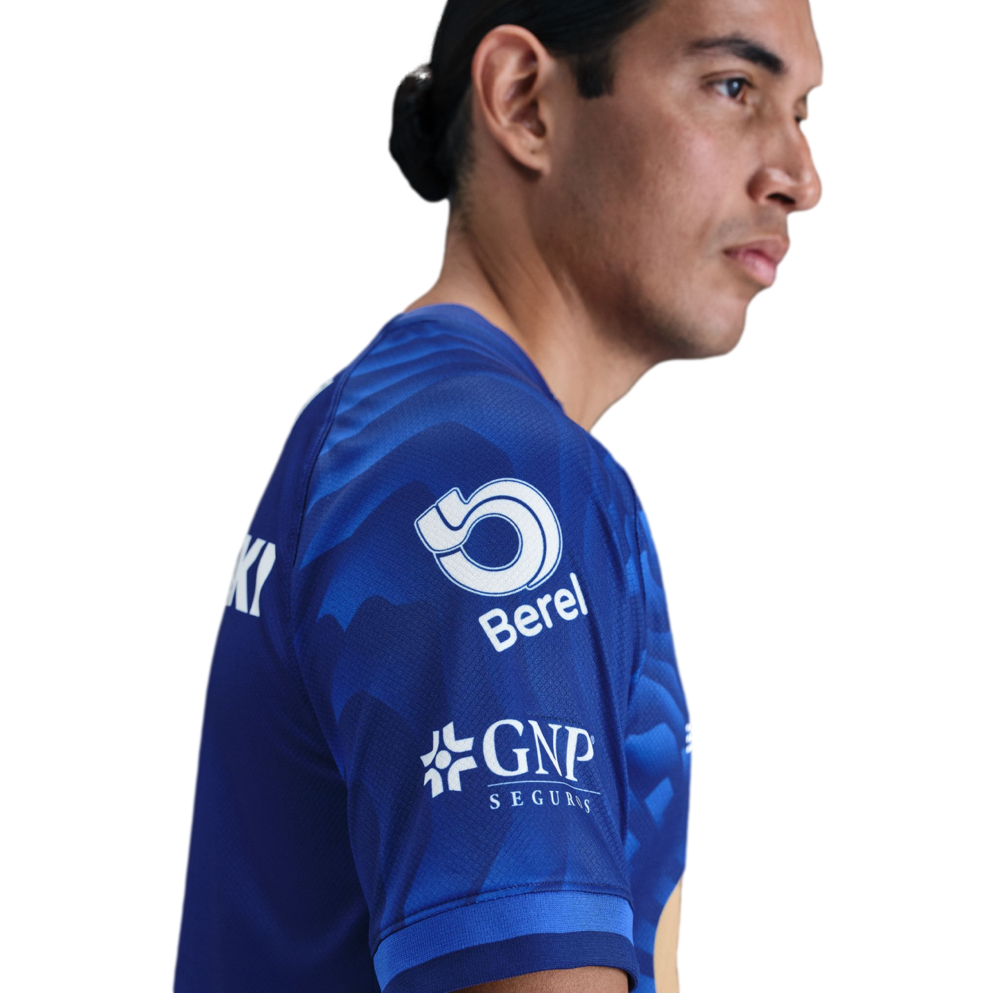 Side profile of a man wearing a blue sports jersey with "Berel" and "GNP Seguros" logos on the sleeve, set against a plain white background.