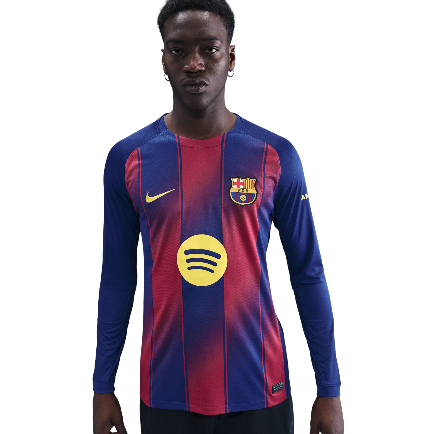 Man wearing a long-sleeved blue and garnet FC Barcelona soccer jersey with yellow Nike and Spotify logos, against a solid black background.
