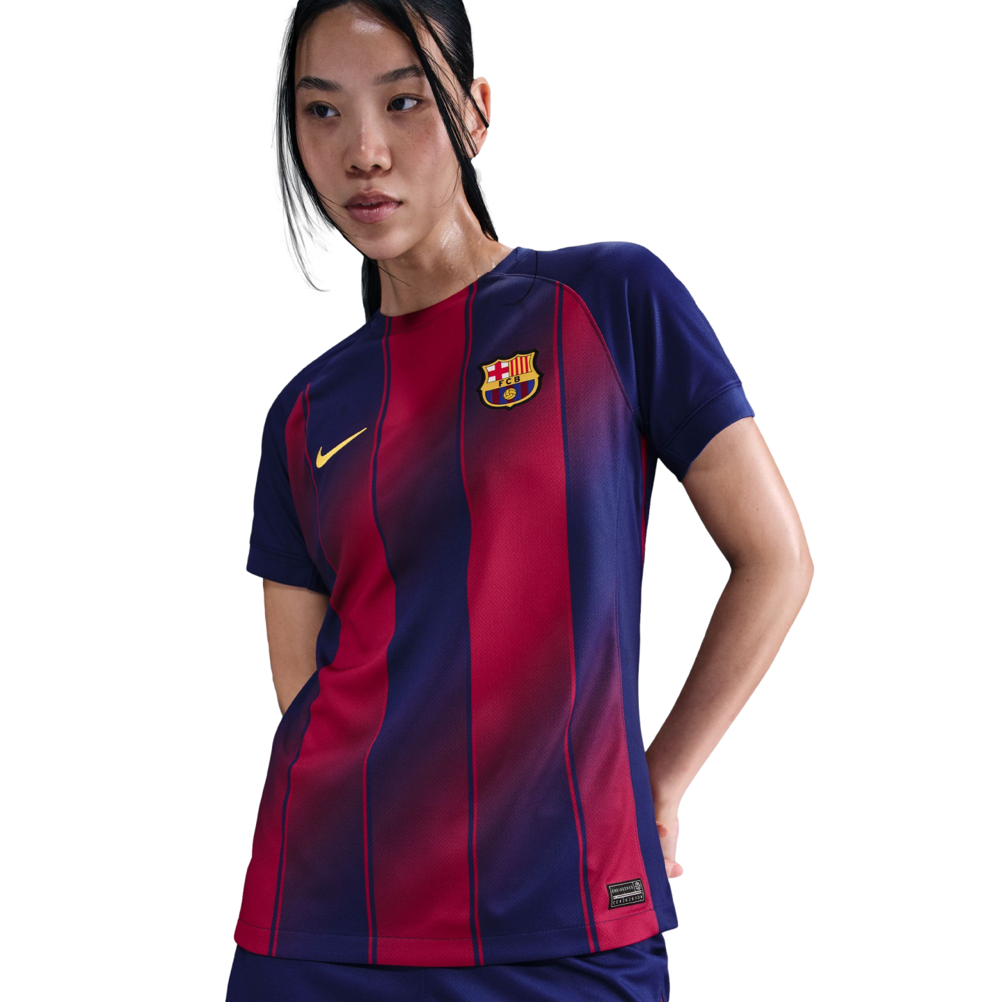 A woman wearing a navy blue and red striped FC Barcelona soccer jersey with a yellow Nike swoosh and club crest, posed against a black background.