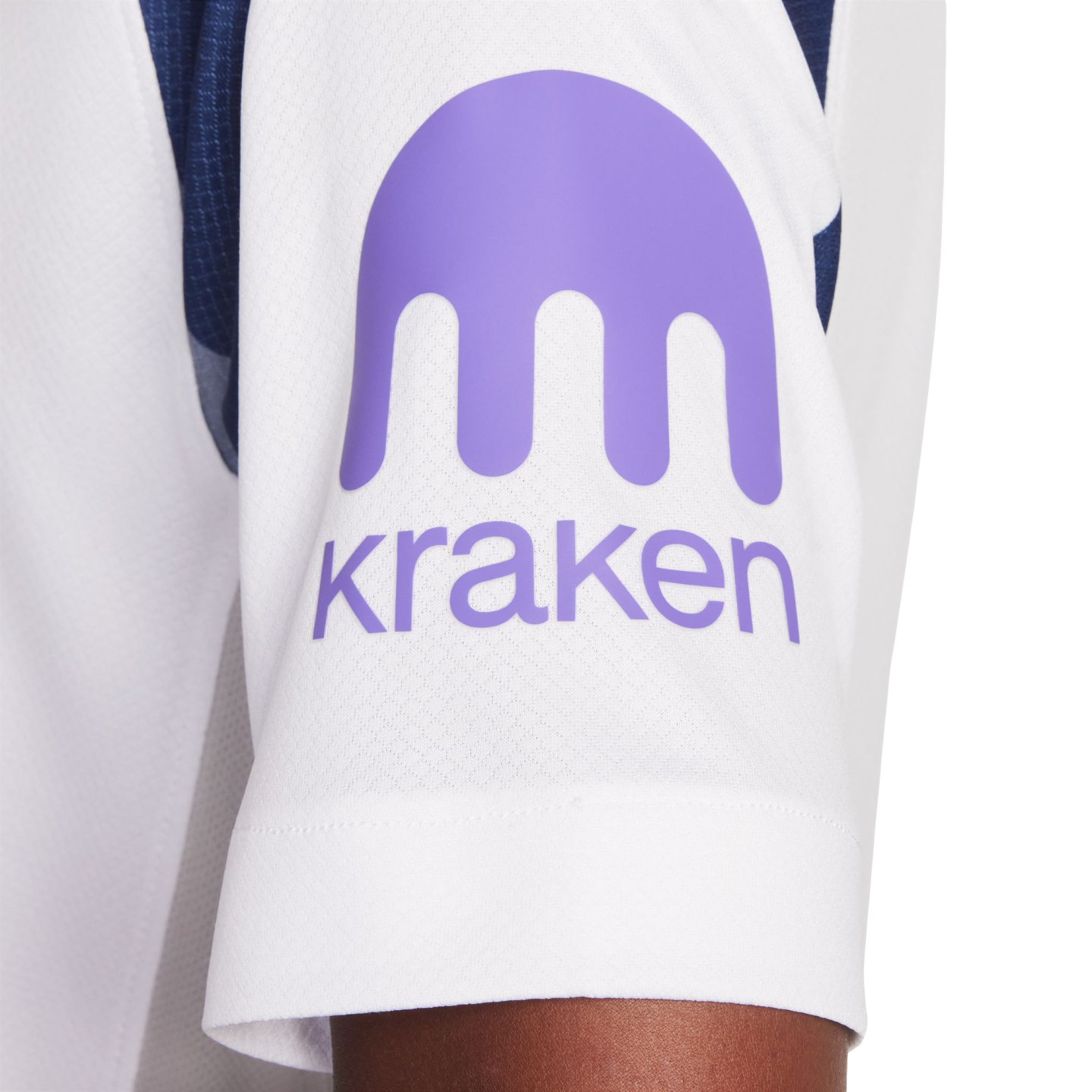 Close-up of a white jersey sleeve featuring a purple logo consisting of an abstract kraken shape above the word "kraken" in lowercase.