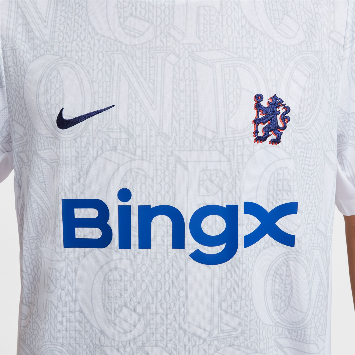 Close-up of a white Chelsea FC football jersey featuring a Nike swoosh, the team's lion crest, and a large blue BingX sponsor logo.