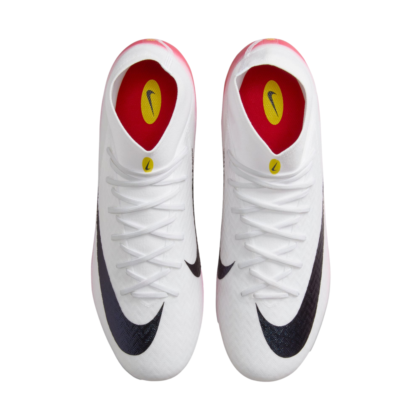 Top-down view of a pair of white Nike soccer cleats with black swooshes and red and yellow interior details on a black background.