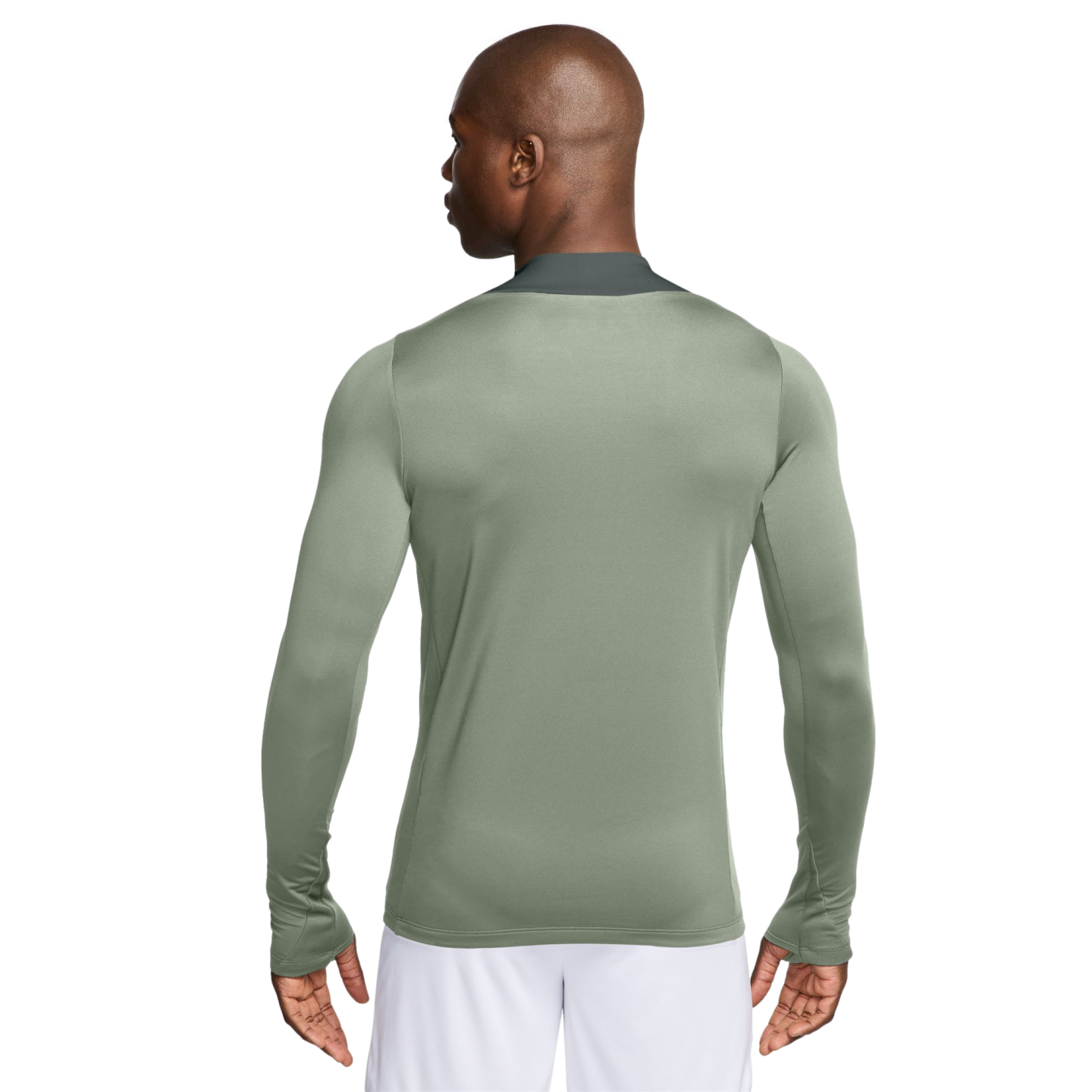 Rear view of a man wearing a sage green long-sleeved athletic shirt with thumbholes and white shorts.
