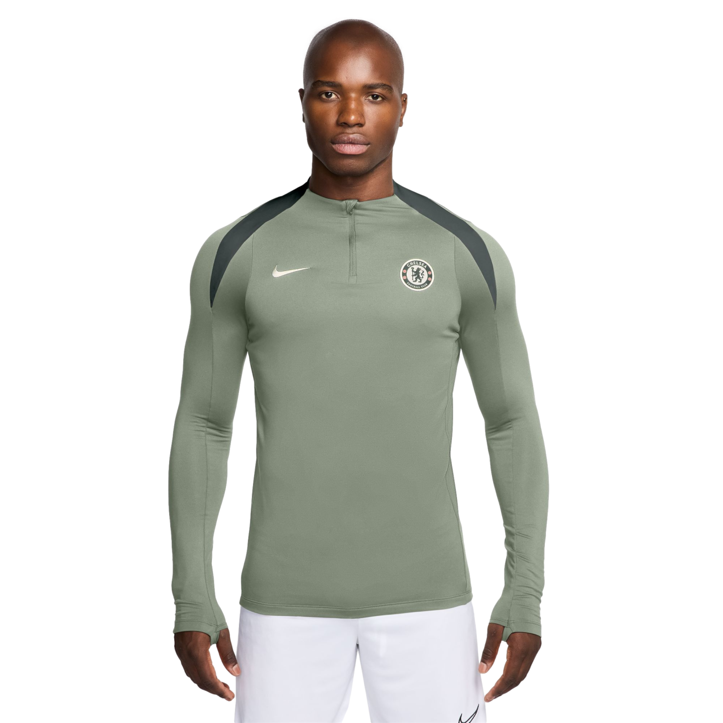 A man models a sage green Nike Chelsea FC quarter-zip training top with dark grey shoulder panels, pictured against a white background.