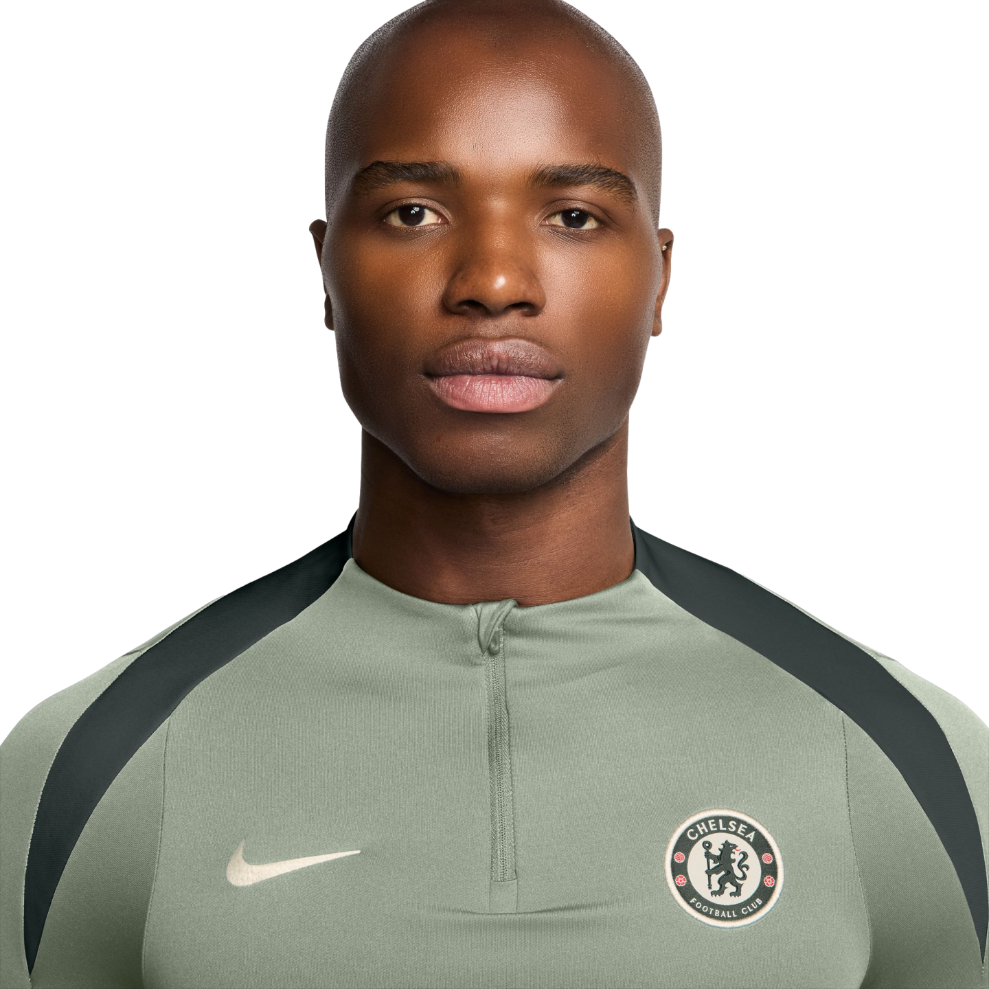 Headshot of a bald man wearing a sage green Nike quarter-zip shirt with a Chelsea FC crest against a white background.