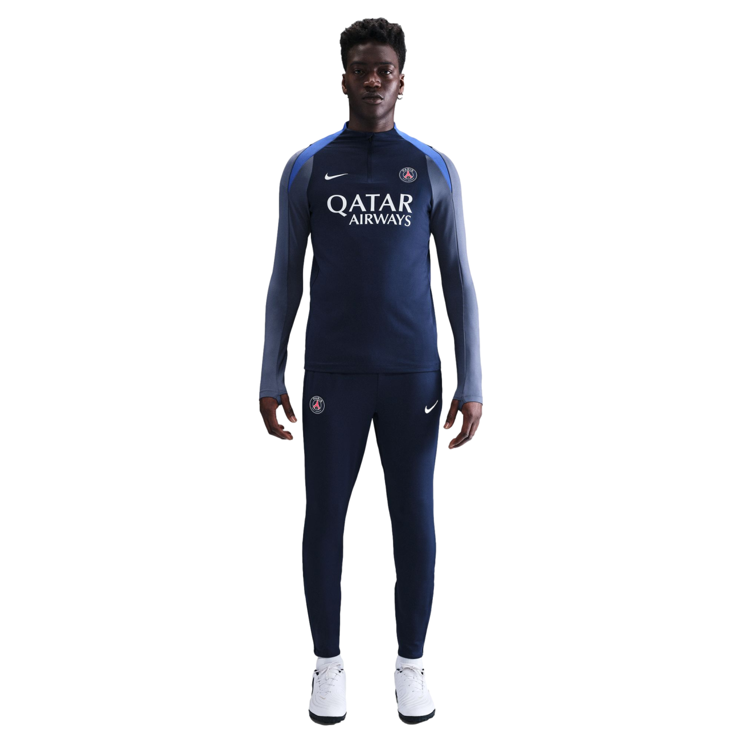 A man wearing a navy blue Nike PSG tracksuit with a Qatar Airways logo stands against a white background.