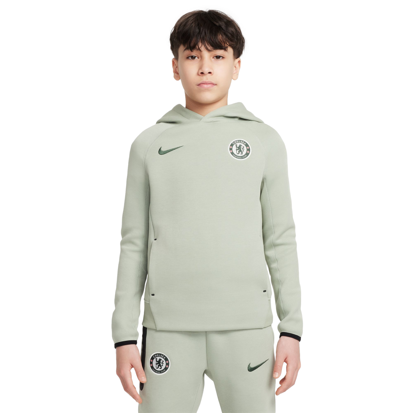 A boy wearing a light green Nike tracksuit with Chelsea FC crests on the hoodie and pants, set against a white background.