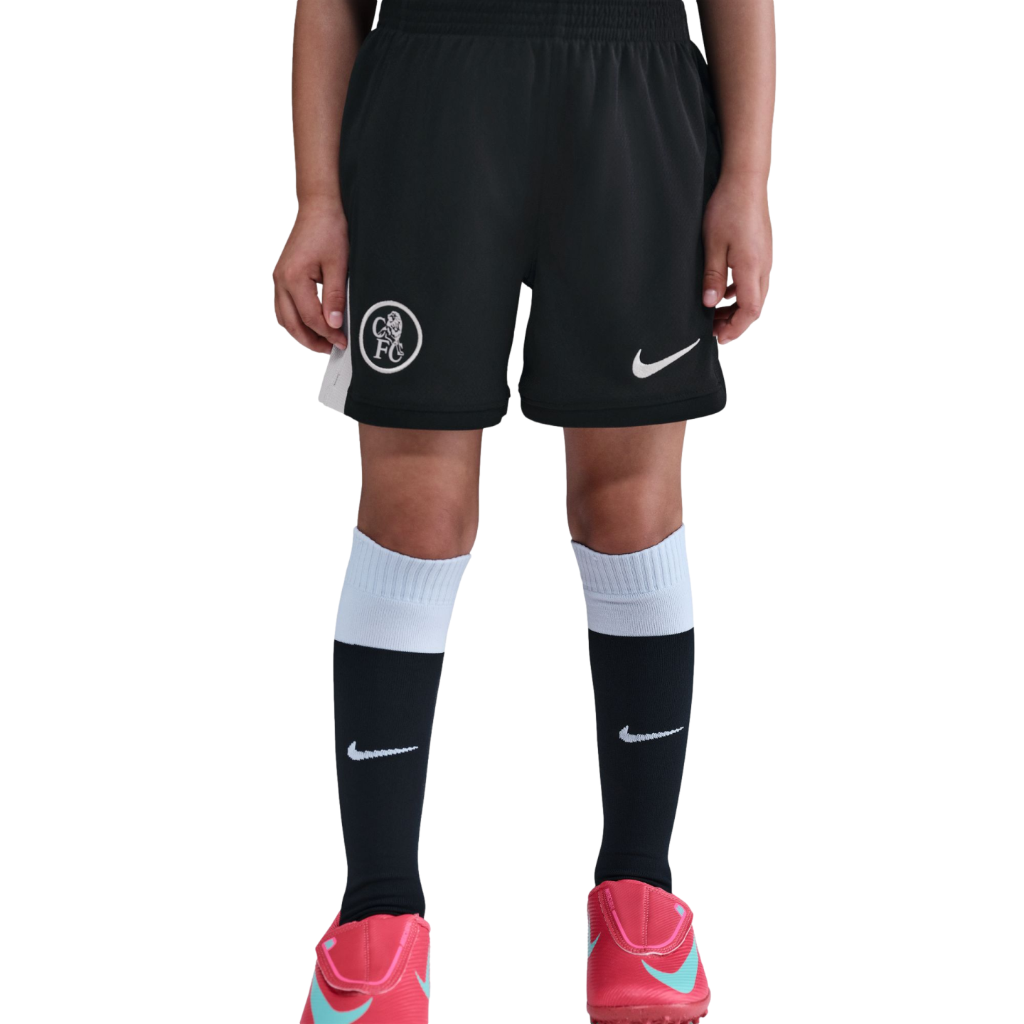 Person wearing black Chelsea FC soccer shorts, black and white Nike socks, and pink Nike soccer cleats against a black background.