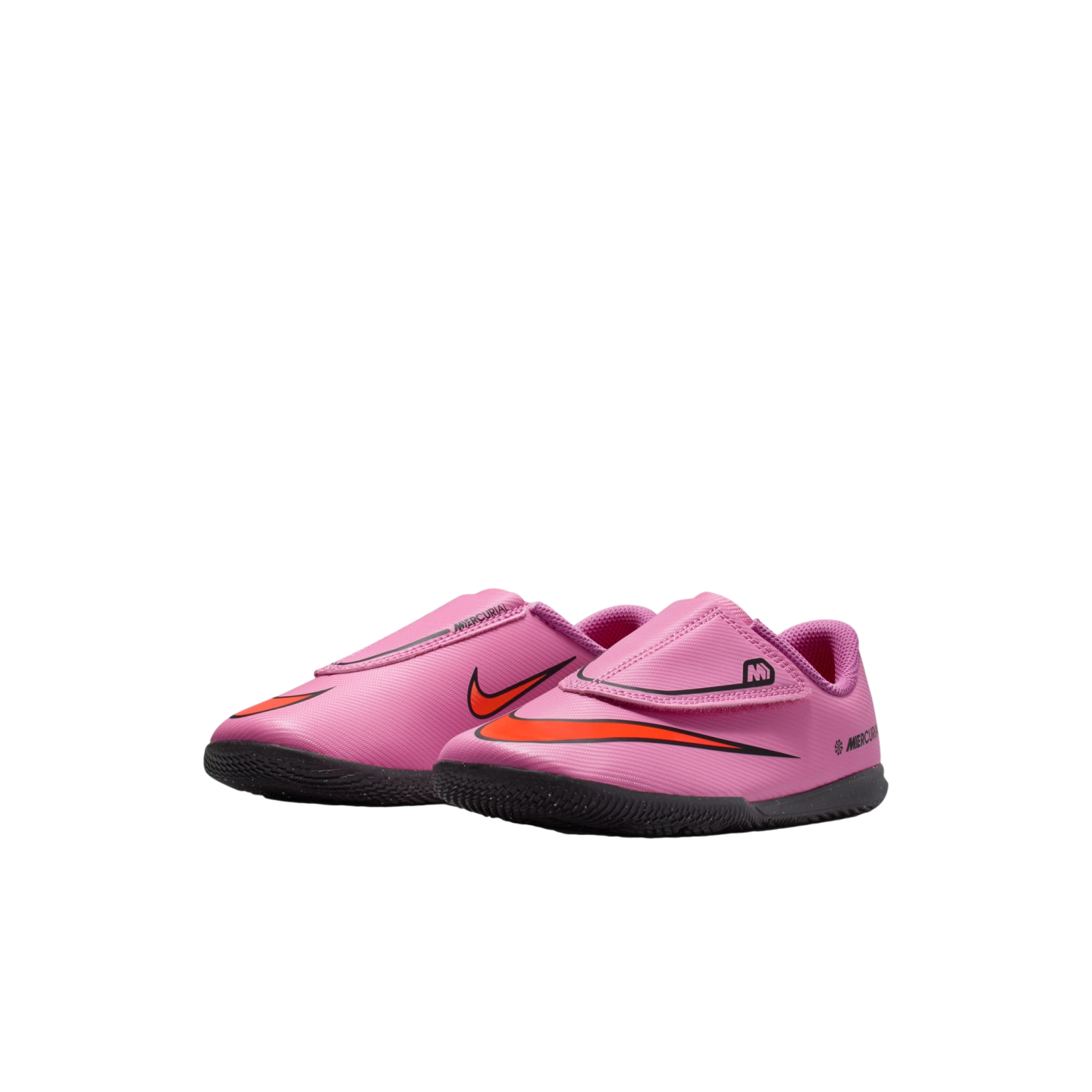 A pair of pink toddler Nike Mercurial indoor soccer shoes with orange swooshes and black soles, isolated on a black background.