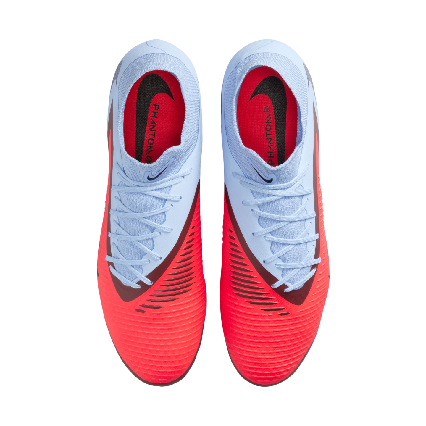 Top-down view of light blue and vibrant red Nike Phantom football boots with white laces, set against a solid black background.