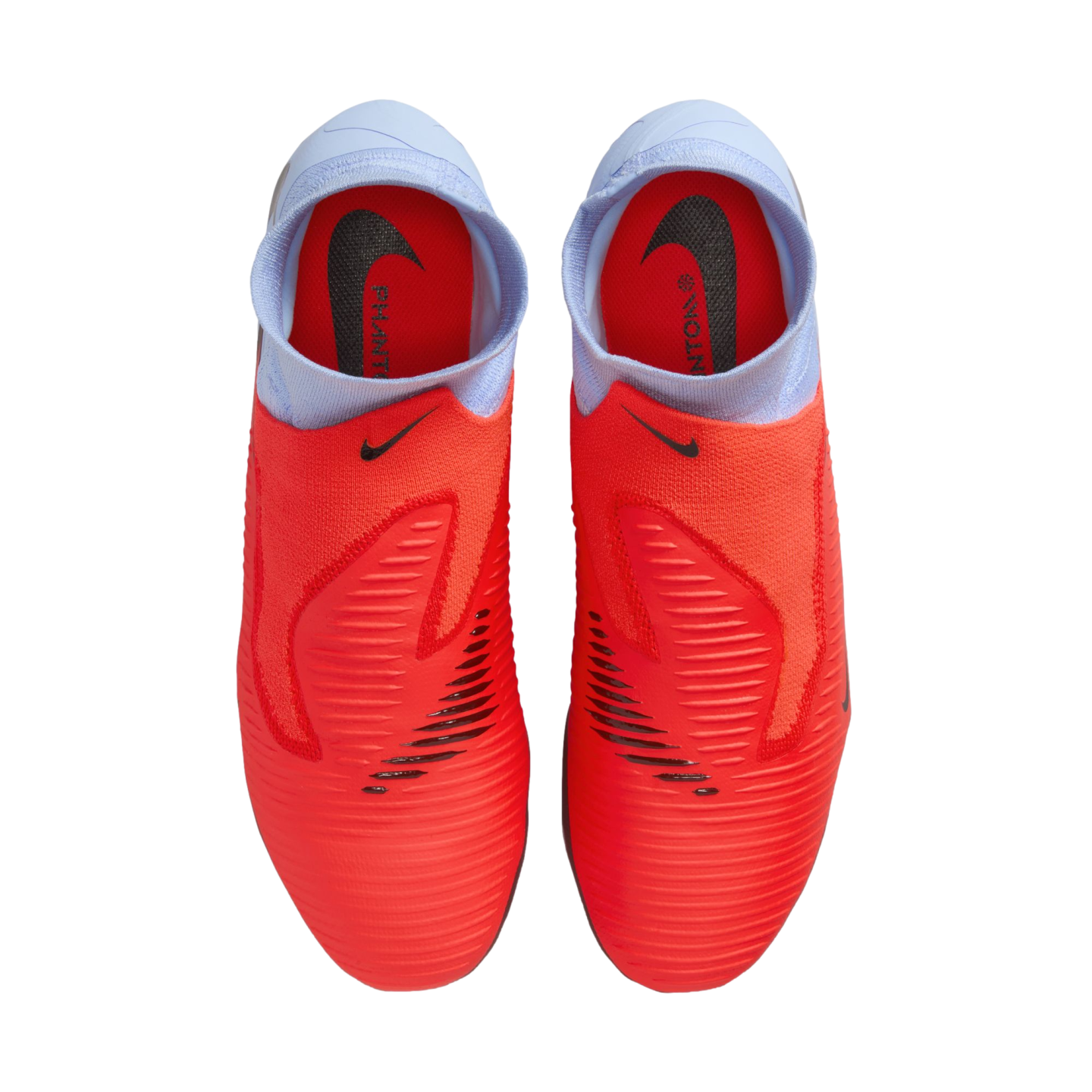 Top-down view of bright red Nike Phantom soccer cleats featuring light blue sock-like collars and black Nike logos, set against a solid black background.