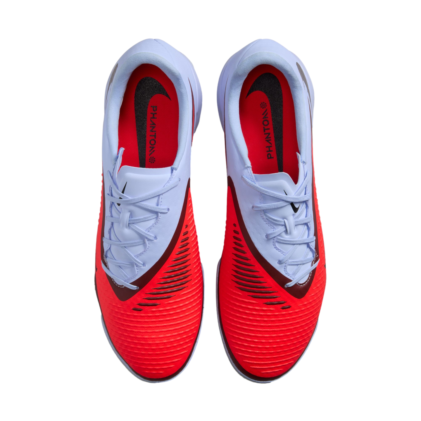 Top-down view of a pair of red and white Nike Phantom soccer cleats against a black background.