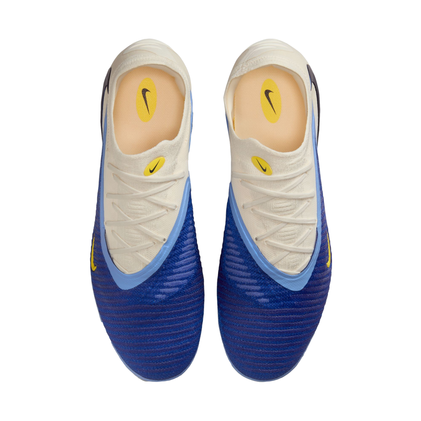 Top-down view of a pair of blue and white Nike soccer cleats with yellow accents and a textured blue forefoot.