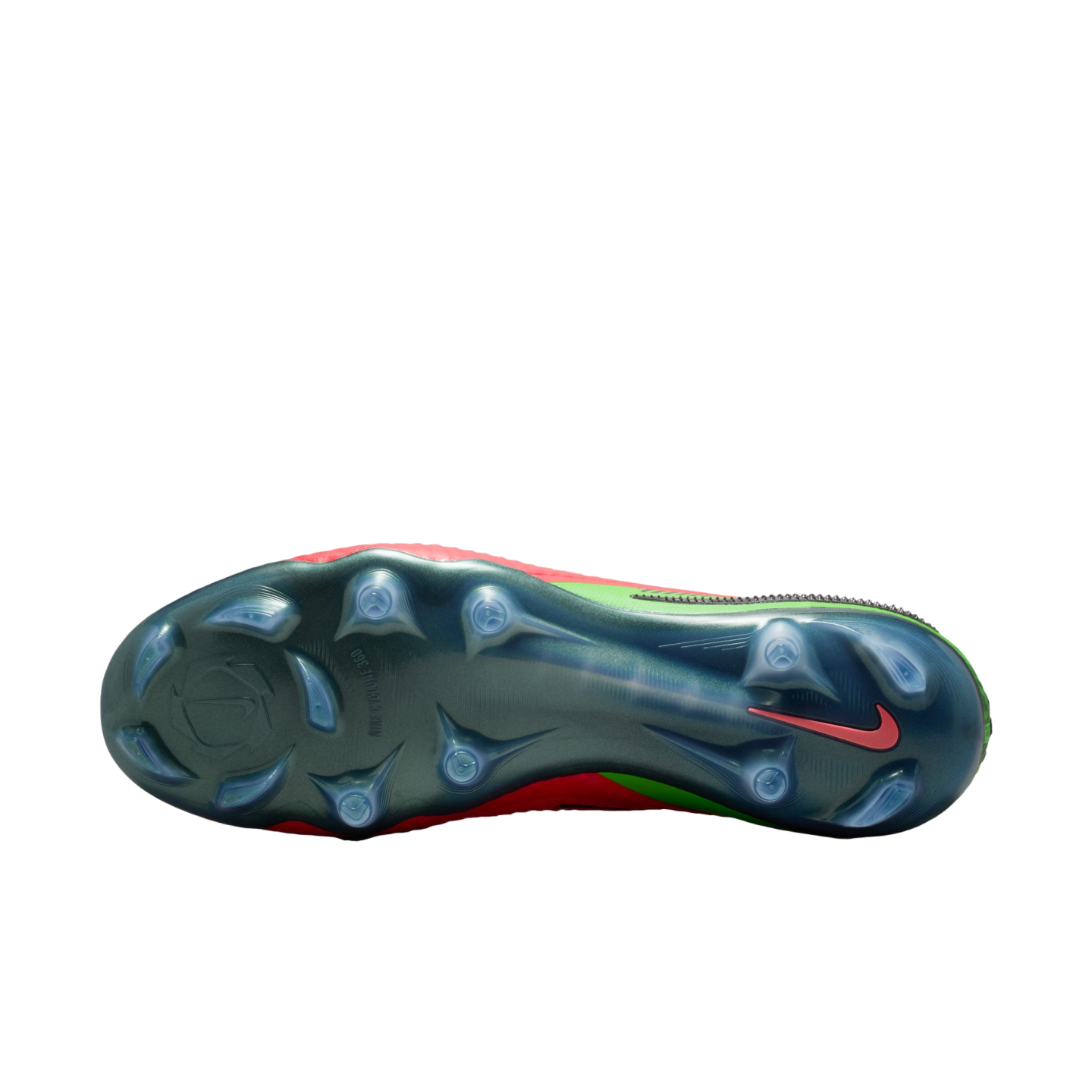 A bottom-up view of a Nike soccer cleat featuring an iridescent dark green soleplate with translucent studs. A small red Nike swoosh is visible near the heel, and the edges of the red and neon green upper are visible against a solid black background.