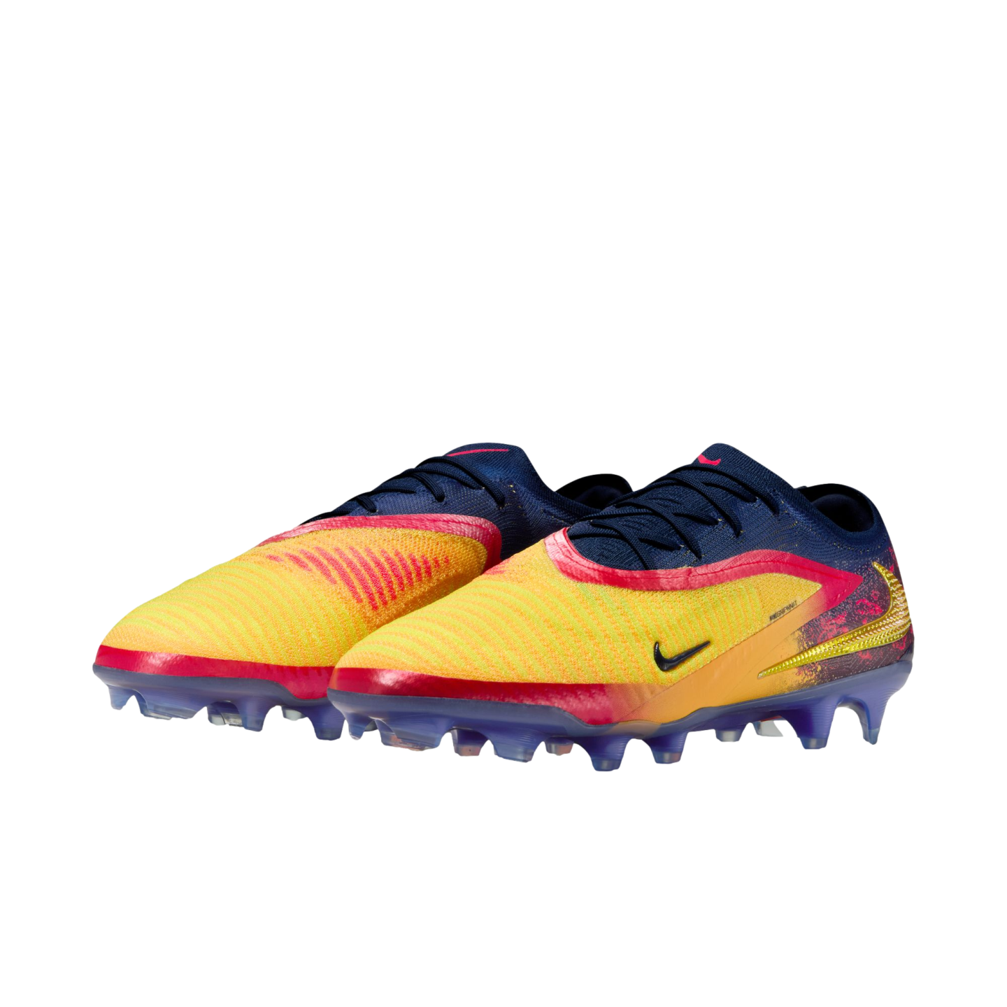 A pair of Nike soccer cleats with a yellow, orange, and navy blue gradient upper and purple soles, set against a solid black background.