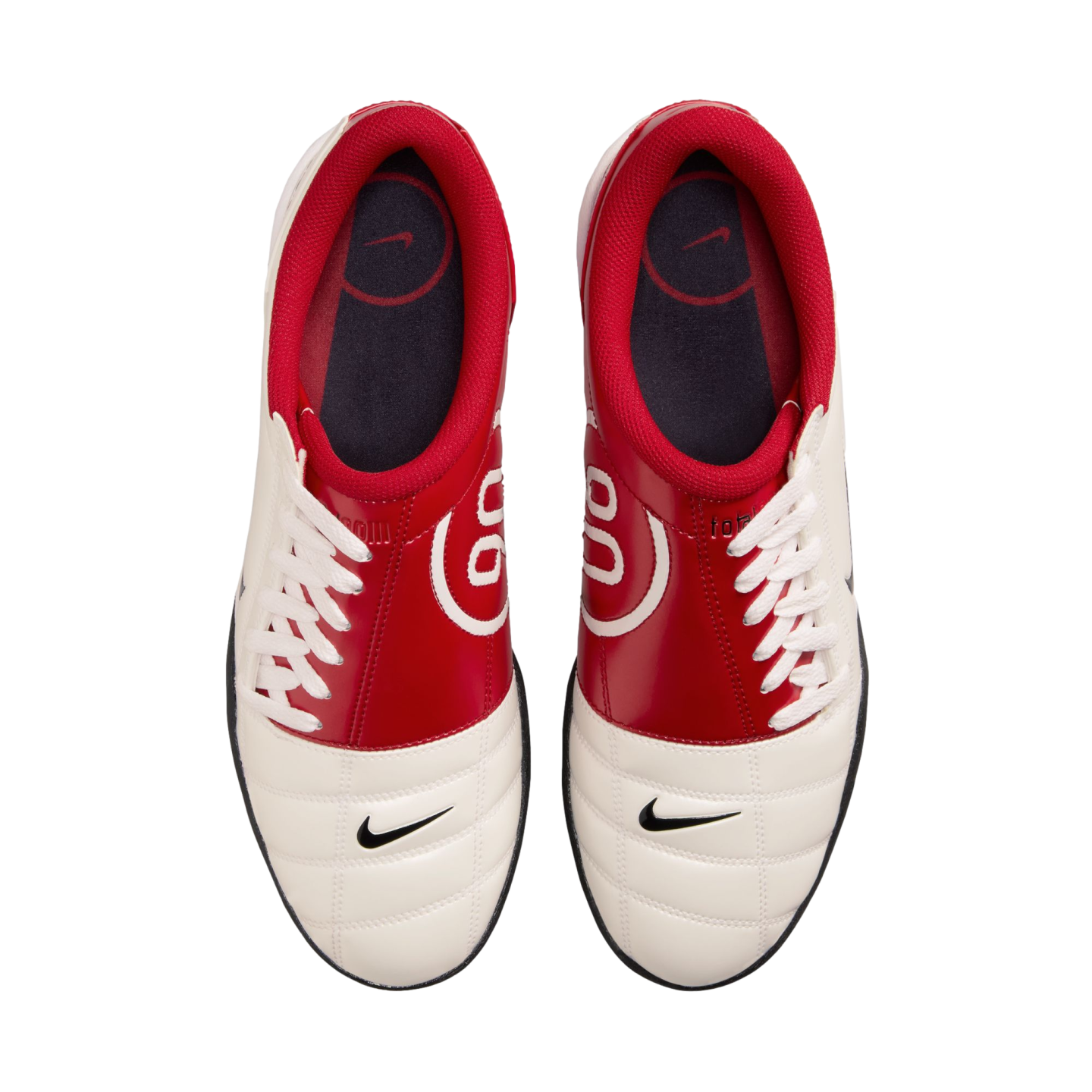 Top-down view of red and white Nike Total 90 sneakers with black swooshes on the toes and white laces.